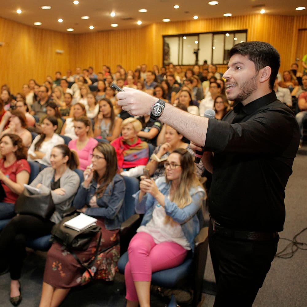 Rodrigo Bueno conduzindo treinamento para sala cheia